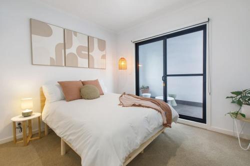 a bedroom with a bed and a large window at 'Laidback Lygon' A Two-storey Inner-city Oasis in Melbourne