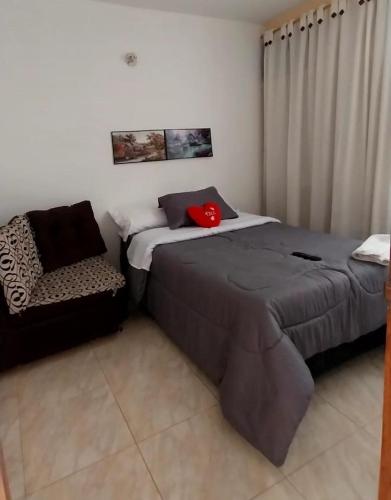 a bedroom with two beds and a chair at acogedora casa Rochi in Guaduas