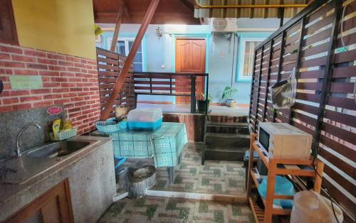 - une cuisine avec un évier et une table dans une chambre dans l'établissement Ruen Thai Ban Rim Nam, à Kamphaeng Phet