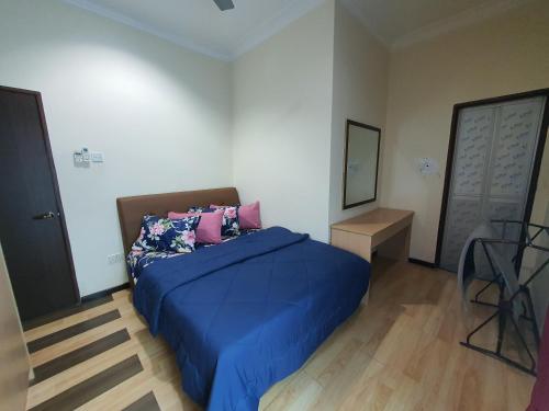 um quarto com uma cama com lençóis azuis e almofadas cor-de-rosa em VILLA SARA PRIVATE POOL ALOR SETAR em Langgar