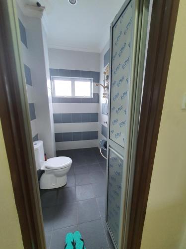 uma casa de banho com um WC e uma porta de vidro em VILLA SARA PRIVATE POOL ALOR SETAR em Langgar