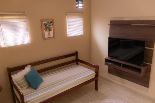 un soggiorno con panca e TV a schermo piatto di Recanto Sol e Lua a Parati