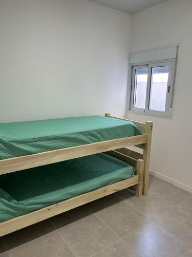 a bedroom with two bunk beds and a window at Departamento tornquist por día in Tornquist