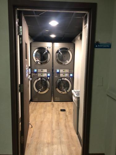 a hallway with three washing machines in a room at Universal-Disney Dream 1211 Studio - The Enclave in Orlando