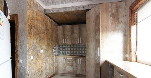 a kitchen with wooden walls and a counter top at Four Seasons In Carpathians in Migovo