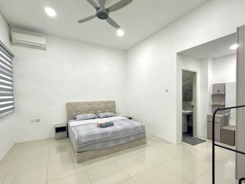 a bedroom with a bed and a ceiling fan at Mojisu Homestay 麻吉宿 in Miri