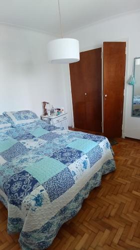 1 dormitorio con 1 cama con edredón azul y blanco en Amplio y luminoso ph en zona guemes, acceso por escalera en Mar del Plata