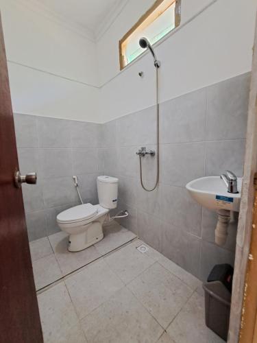 a bathroom with a toilet and a sink at Surfers Beachfont Kuta in Kuta Lombok