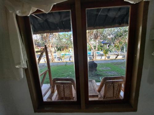 an open window with a view of a playground at Surfers Beachfont Kuta in Kuta Lombok