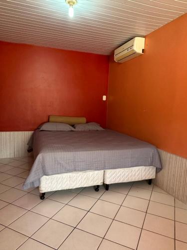 ein Schlafzimmer mit einem Bett in einer roten Wand in der Unterkunft Espaço perainda in Boa Vista