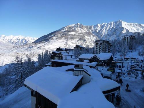 a snow covered mountain with buildings and snow covered roofs at Maison Les Orres, 2 pièces, 6 personnes - FR-1-322-593 in Les Orres