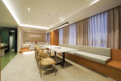 - un salon avec un canapé, une table et des chaises dans l'établissement Hotel Ground27, à Busan