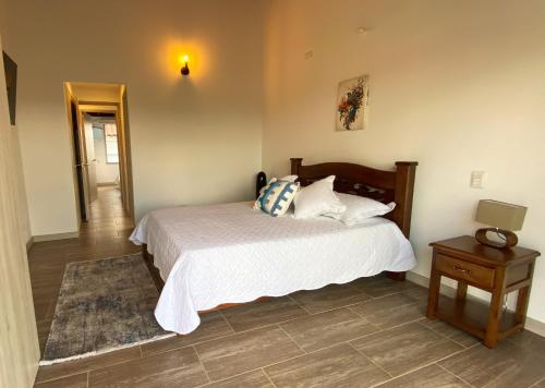 a bedroom with a bed and a table with a lamp at Casa Campestre en zona exclusiva con Jacuzzi, a 10 min del aeropuerto, 20 min parque del café, WiFi, parqueadero privado, vigilancia 24 hrs y amplias zonas sociales in Armenia