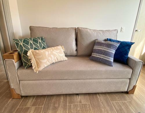 a couch with pillows on it in a living room at Casa Campestre en zona exclusiva con Jacuzzi, a 10 min del aeropuerto, 20 min parque del café, WiFi, parqueadero privado, vigilancia 24 hrs y amplias zonas sociales in Armenia