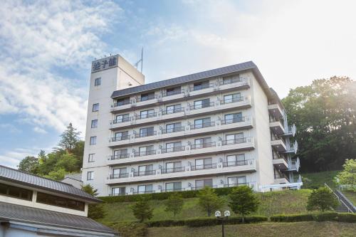 a white building on top of a hill at Mashikokan Satoyama Resort Hotel in Mashiko