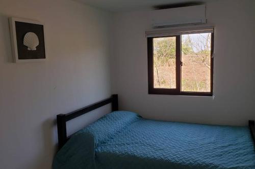 a bedroom with a bed and a window at Primera Casa de Contenedores en Monterrico. in Monterrico