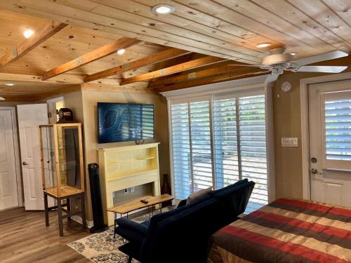a bedroom with a bed and a couch and a tv at The Lake Alfred Citruswood Cabin in Lake Alfred
