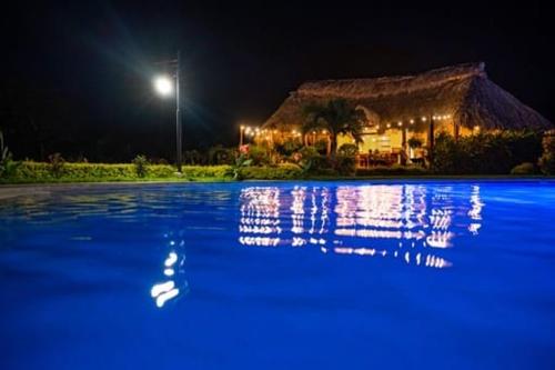 a swimming pool at night with a building in the background at Hotel Victoria in Moyogalpa