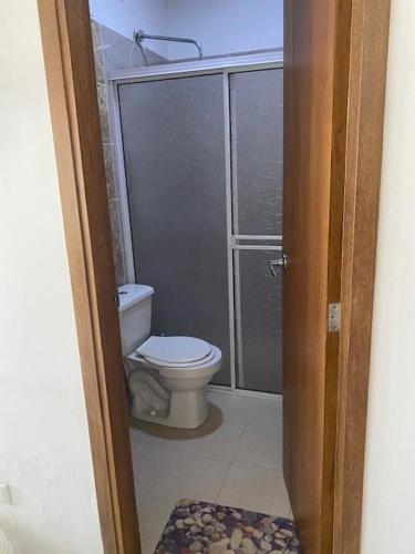 a bathroom with a toilet and a glass shower at Cabañas Paulamar - Apto 2 - Tolu in La Gloria