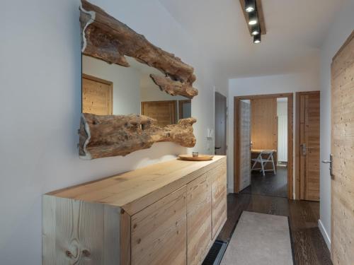une cuisine avec un comptoir en bois et une branche d'arbre sur le mur dans l'établissement Appartement spacieux à Megève, 3 ch, près des pistes, parking privé - FR-1-569-139, à Megève