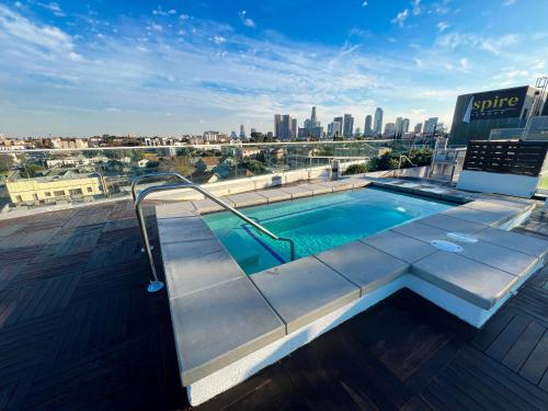 a swimming pool on top of a building with a city skyline at LUXURY LA PENTHOUSE PRIME LOCATION Min from HOLLYWOOD and DOWNTOWN in Los Angeles