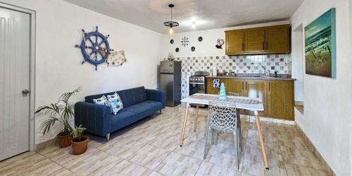 ein Wohnzimmer mit einem blauen Sofa und einer Küche in der Unterkunft Rincón Marino in Sosúa