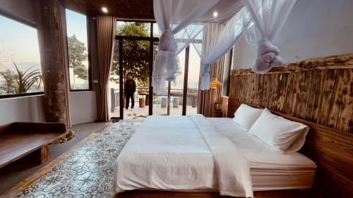 ein Schlafzimmer mit einem Bett und einem großen Fenster in der Unterkunft Pu Luong Paradise in Hương Bá Thước
