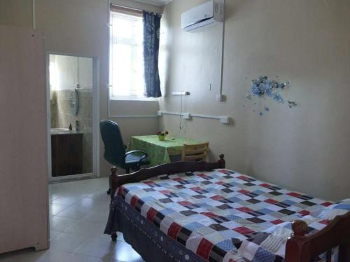 1 dormitorio con 1 cama, 1 mesa y 1 silla en Bois Gournable, en Rodrigues Island