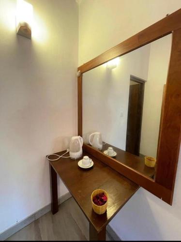 a bathroom with a large mirror and a wooden table at mandodari in Negombo