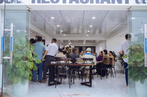 un grupo de personas de pie alrededor de una mesa en una habitación en Thái House en Mộc Châu