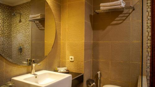 梭羅的住宿－Lorin Dwangsa Solo Hotel，一间带水槽和镜子的浴室