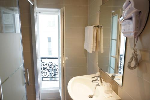 a bathroom with a sink and a mirror and a shower at Hotel Zora in Paris