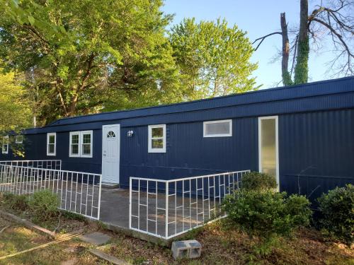 a blue tiny house in the woods at EMMAR Blue & Fishing Lake in Charlotte