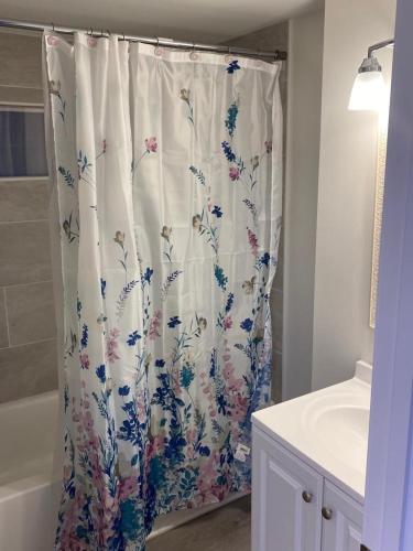 a shower curtain with a floral pattern in a bathroom at EMMAR Blue & Fishing Lake in Charlotte