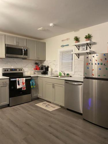 a kitchen with white cabinets and stainless steel appliances at EMMAR Blue & Fishing Lake in Charlotte