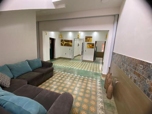 sala de estar con sofá y suelo de baldosa en Hostal Doña Cuca en Capilla de Guadalupe