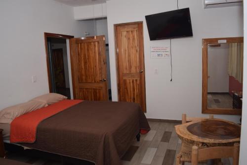 a bedroom with a bed and a tv on the wall at Estancia Vacacional 20 Aguas in Ursulo Galván