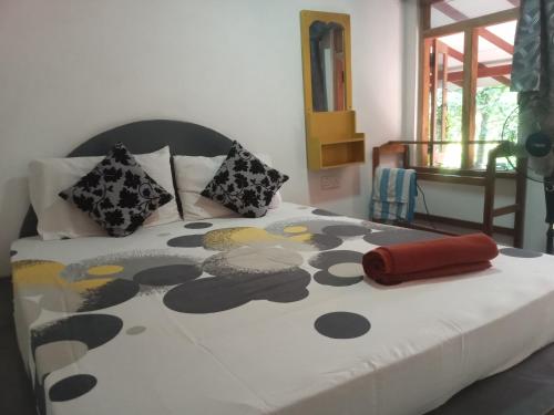 a bedroom with a bed with a black and white comforter at Angry birds homestay in Habarana