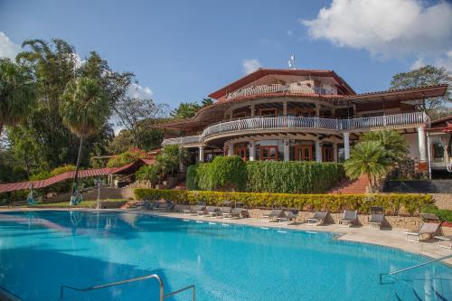 a large house with a large swimming pool at Hotel Martino Spa and Resort in Alajuela City