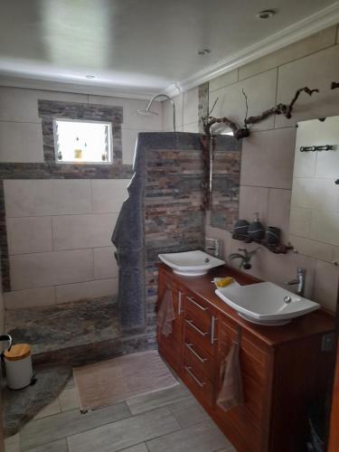 ein Bad mit 2 Waschbecken und einer Dusche in der Unterkunft Le petit vignoble du brûlé marron in Cilaos