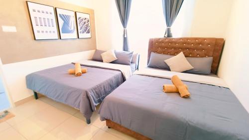 a bedroom with two beds with orange pillows at Kulai d'putra suites beside ioiMall near Airport and JPO in Kulai