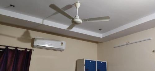 ventilador de techo en la sala de estar con techo en RAYUDUGARILLU MEN'S DELUXE HOSTEL en Vijayawāda