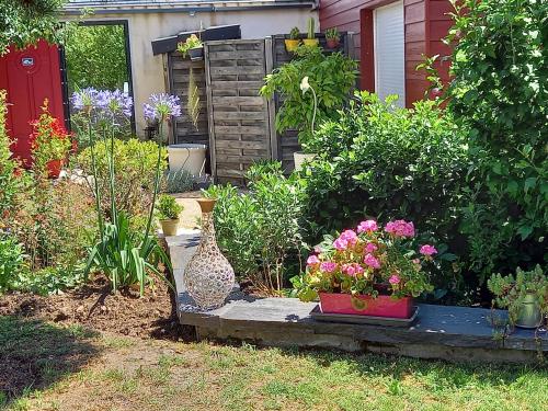 einen Garten mit Blumen und Pflanzen im Hof in der Unterkunft l'annexe du jardin in Saint-Doulchard