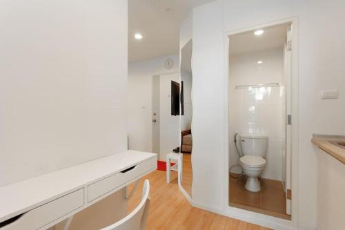 bagno bianco con servizi igienici e specchio di Fully Furnished Studio Apartments a Bangkok