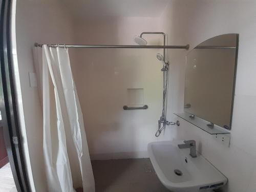 a bathroom with a sink and a shower with a mirror at Palawan-Residence B&B in Puerto Princesa City