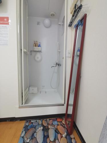 a bathroom with a shower with a mirror at grori house in Musashino