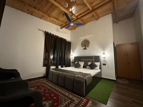 een slaapkamer met een bed en een plafondventilator bij Heaven by lake & woods in Bhīm Tāl
