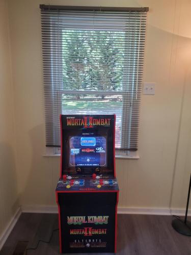 a pinball machine in a room with a window at Private Single Level Standalone House Large Lot - 3 Bedrooms in Charlotte
