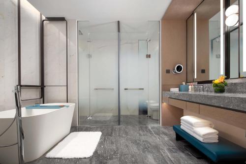 a bathroom with a tub and a shower and a sink at Crowne Plaza Jinan Runhua in Jinan