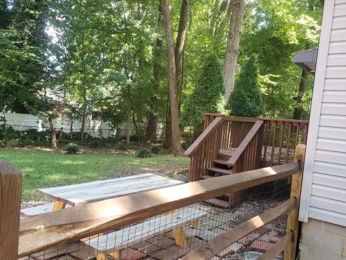 a wooden deck with a chicken coop next to a house at Private Single Level Standalone House Large Lot - 3 Bedrooms in Charlotte